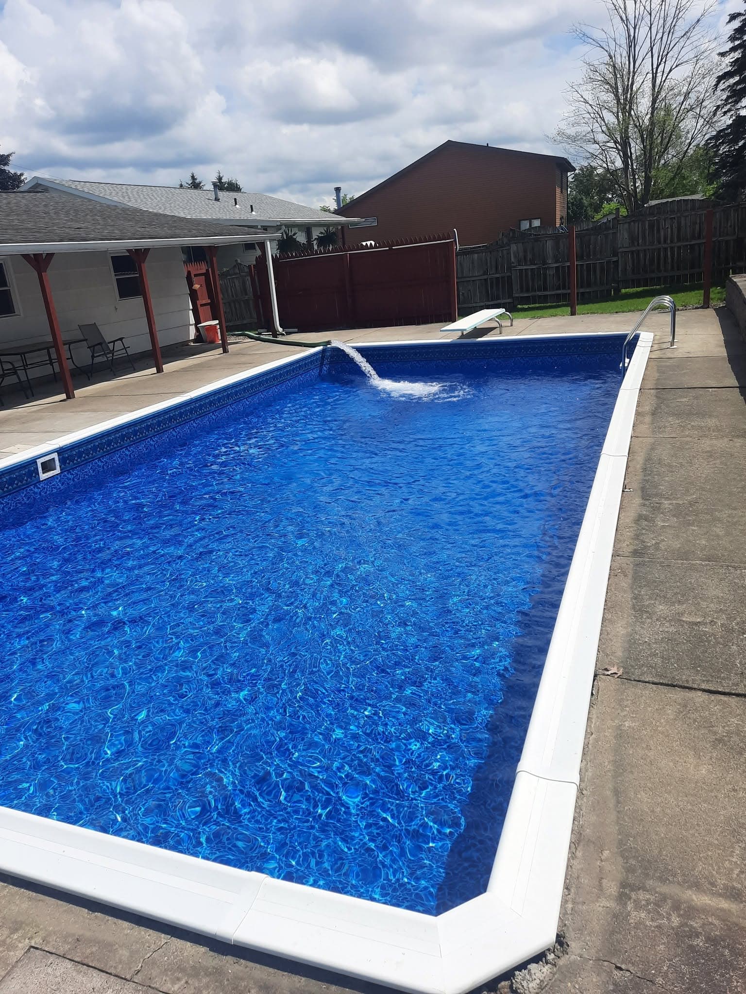 Pool after: new white coping, new liner, crystal-clear blue water